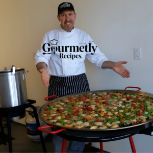 Chef presenting a vibrant paella dish as featured on Gourmetly Recipes